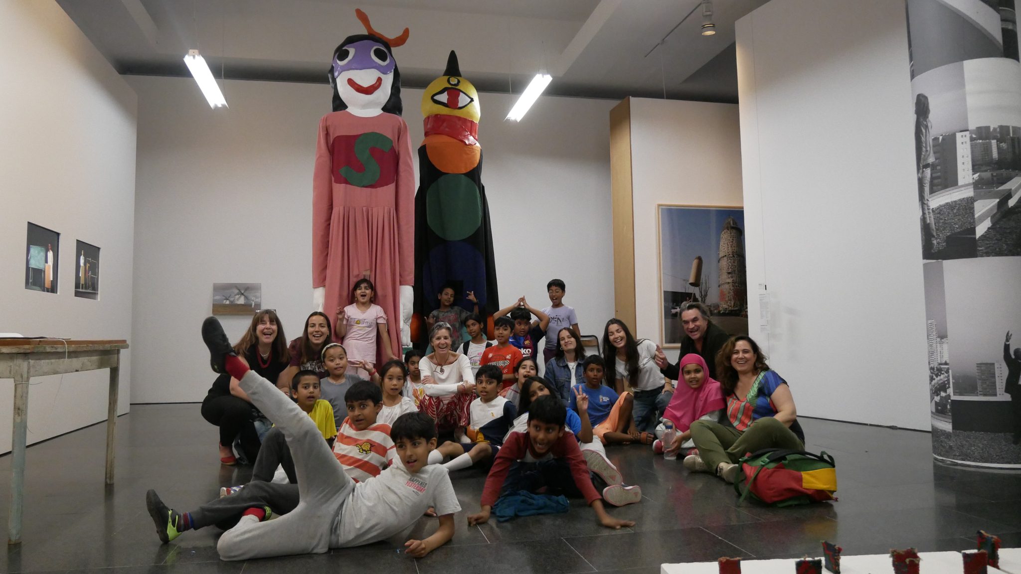 Nens i nenes del Casal i l'artista Jordi Colomer posen amb els dos gegants que formen part de l'obra 'El Balcó'.