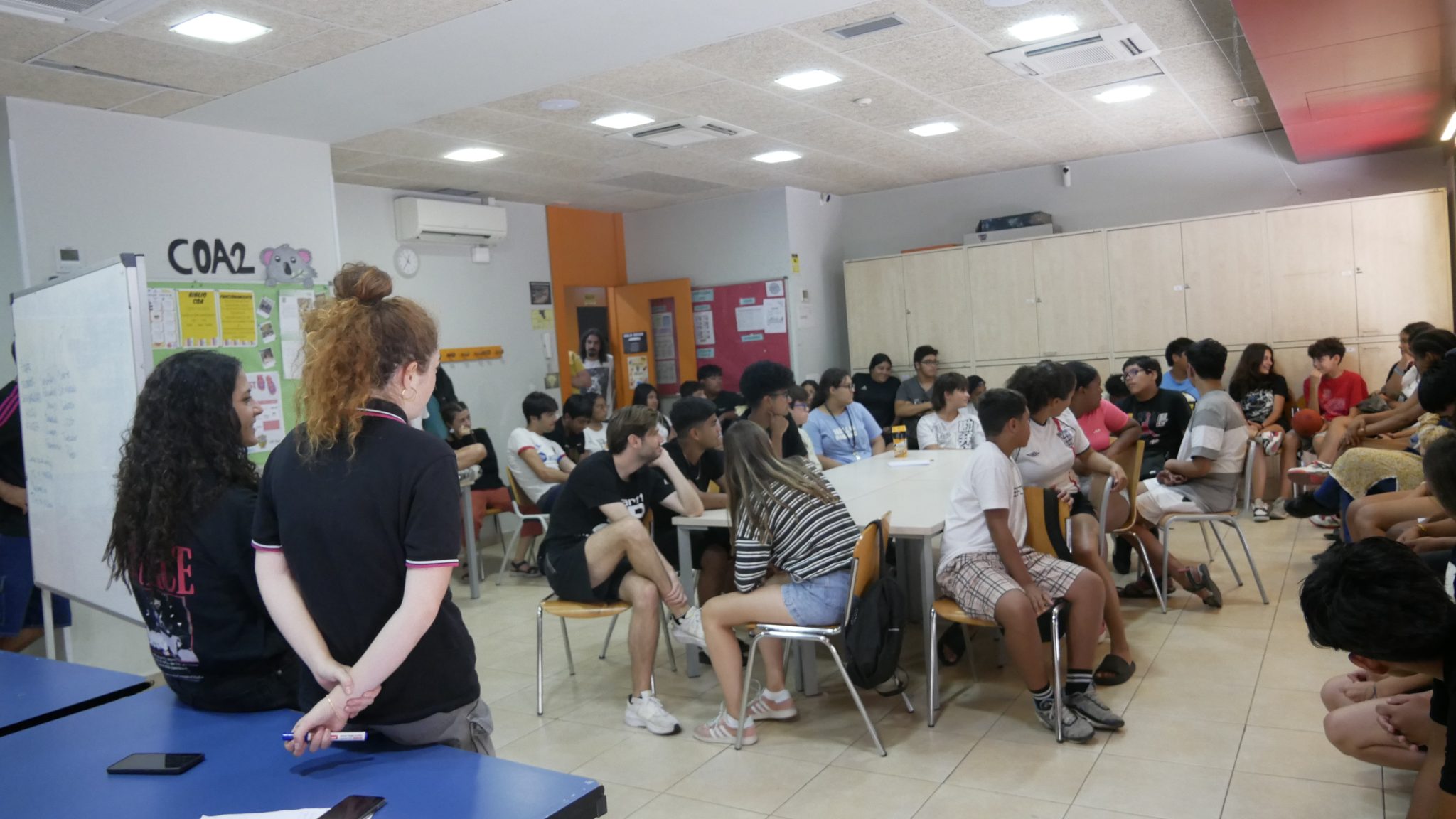 Nois i noies en una aula, mentre participen en una dinàmica del taller.